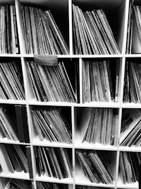 a black and white photo of a shelf full of records